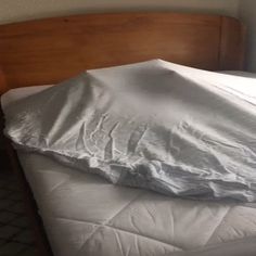 an unmade bed with white sheets on it