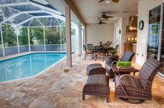 a patio with chairs and tables next to a swimming pool