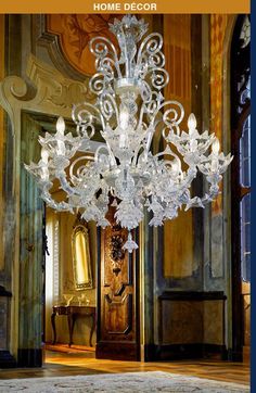 an ornate chandelier hangs from the ceiling in front of a doorway with gold trim