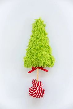 a green christmas tree on top of a candy cane