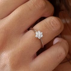 a woman's hand with a diamond ring on it