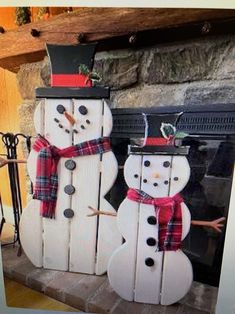 two snowmen are standing next to each other in front of a fire place and fireplace