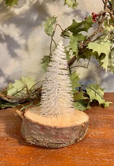 a small white christmas tree sitting on top of a wooden table