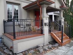 a house with an iron railing and wooden steps