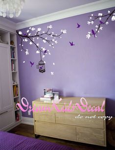 a bedroom with purple walls and white flowers on the wall, an open bookcase is next to it