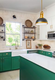 a kitchen with green cabinets and white counter tops