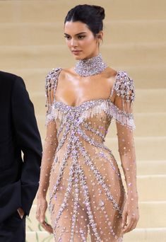 a woman in a dress walking down the stairs