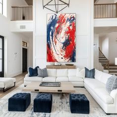 a living room filled with furniture and a large painting hanging on the wall above it