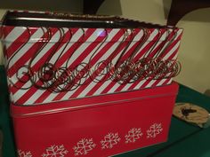 a red and white box filled with lots of silverware sitting on top of a green table