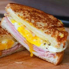 a ham and egg sandwich cut in half on a cutting board