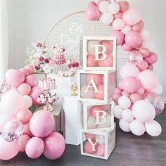 a baby shower party with balloons, cake and other items in pinks and whites