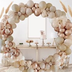 a table topped with lots of balloons in front of a white wall and mirror behind it