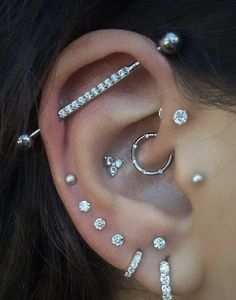 a woman with ear piercings and pearls on her ears is wearing an ear cuff