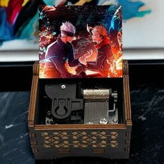 a wooden music box with an image of naruto and sashirt on it