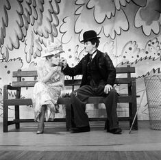 a man and woman sitting on a bench talking to each other