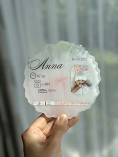 a person holding up a baby announcement card