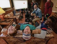 three people are laying on the floor with cameras around them