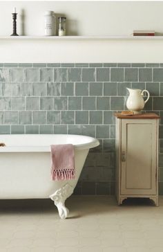 a white bath tub sitting in a bathroom next to a wall with writing on it