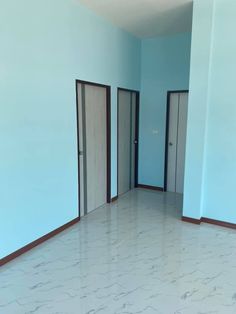 an empty room with blue walls and doors