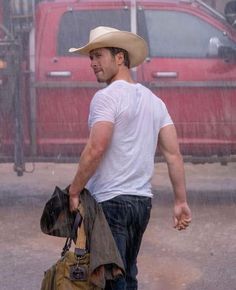 a man walking in the rain carrying a bag