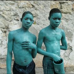 two young boys with blue paint on their body and hands are standing next to each other