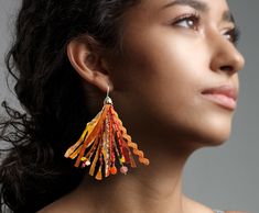 These handmade, colorful statement earrings are whimsical, warm and flowing in beautiful shades of yellow, salmon, orange and pink. Made with a mixture of  rubies, carnelian, citrine, flourite, rhodonite, goldstone, topaz, seed beads, Sari Silk, and mixed fabrics, these earrings are a soft, yet colorful  addition to your style. A little boho and a little elegance, all wrapped up into one! The connector at the top is silver. I can customize these to fit any color palette as well! Bohemian Orange Fringe Earrings, Bohemian Orange Tassel Earrings, Orange Beaded Fringe Earrings As Gift, Orange Fringe Beaded Earrings As Gift, Handmade Elegant Orange Beaded Earrings, Orange Fringe Beaded Earrings For Gift, Orange Fringe Dangle Earrings, Unique Orange Earrings With Dangling Beads, Bohemian Orange Tassel Earrings For Party