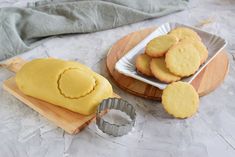 some cookies are sitting on a wooden board next to a cookie tin and a plate