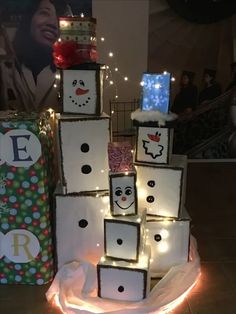 a snowman made out of boxes with lights around it