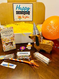 a birthday gift box filled with confetti, candy and other items on a table