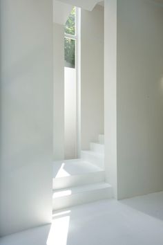 an empty room with white walls and stairs