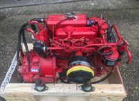 a red engine sitting on top of a wooden crate