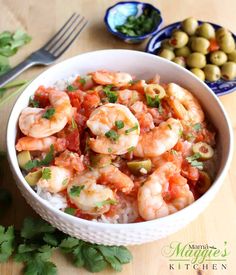 a bowl filled with shrimp and rice next to olives