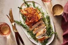 a white plate topped with meat covered in herbs