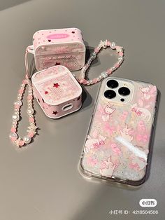 two cell phones are sitting next to each other on a table, one is pink and the other is white