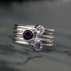 "Set of Five Sterling Silver Stacking Rings Rich, saturated purple amethysts complimented by a sparkling clear topaz. Five handmade sterling silver stacking rings. Three smooth ring bands are set with a gorgeous variety of faceted gemstones. 2 plain ring bands are given a hammered texture & a bright polished finish. Wear them all together, mix and match, or wear one elegant ring at time. 5mm Purple Amethyst 4mm Lavender Amethyst 4mm Clear Topaz and two hammered stacking rings. Each ring is 1 Amethyst Ring With Gemstone Accents For Anniversary, Multi-stone Amethyst Jewelry Round Cut, Elegant Silver Stackable Amethyst Ring, White Topaz Rings With Gemstone Accents For Gift, Gift Rings With White Topaz And Gemstone Accents, White Amethyst Ring For Anniversary, Silver Stackable Rings With Gemstone Accents For Anniversary, Silver Stackable Amethyst Birthstone Rings, Sterling Silver Amethyst Ring With Gemstone Accents For Anniversary