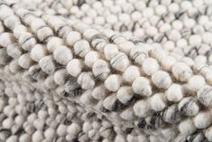 a close up view of a white and black rug with some sort of pattern on it