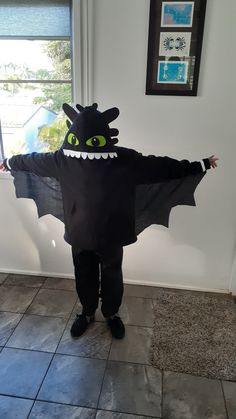 a person in a costume that is standing on a tile floor with his arms out