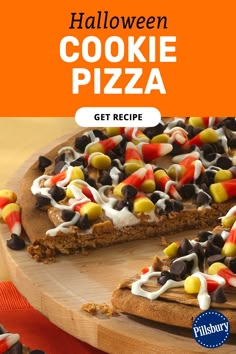 halloween cookie pizza on a wooden cutting board with the words get recipe written below it