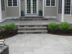 an outdoor patio with steps leading to the front door