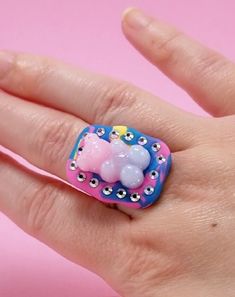 The setting is hand-sculpted by me and set with Swarovski crystals and a resin gummy bear. The ring band is adjustable. Please be aware that since this is handmade, it could break if dropped or hit.  I do take custom orders! Please follow me on tiktok: PriscillaBelladonna Dope Jewelry, Gummy Bears, Cocktail Rings, Blue Yellow, Pink Blue, Rings Statement, Band Rings, Swarovski Crystals, Statement Rings