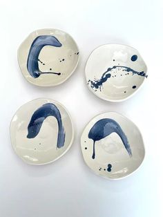 three white plates with blue designs on them sitting next to each other in front of a white background