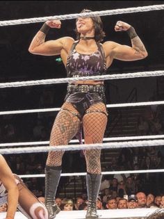 a woman standing on top of a wrestling ring