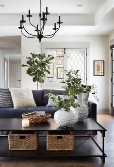 a living room with a couch, coffee table and vases on top of it