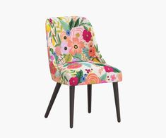 an upholstered chair with colorful flowers and leaves on the back, against a white background