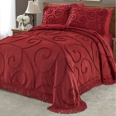 a red comforter set with fringe trim