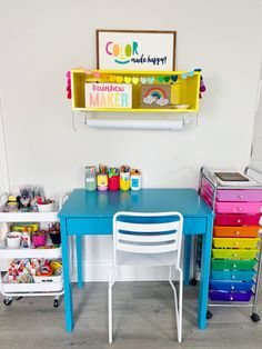 there is a blue desk and chair in the children's playroom with lots of toys