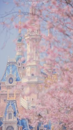 the castle is surrounded by pink flowers and blue roofing on it's side