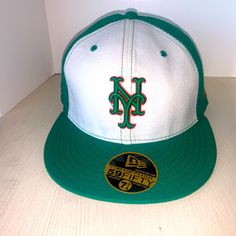 a green and white baseball cap with the letter m on it's front side