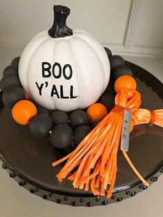 a cake decorated to look like a pumpkin with boo y'all written on it