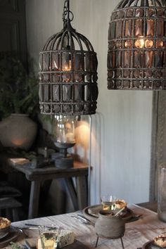 a table topped with lots of food and two lights hanging from it's ceiling